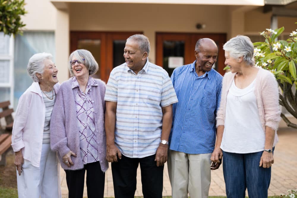 Cheerful senior men and women standing at retirement home