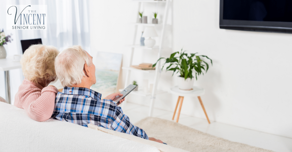 A senior couple relaxing on sofa watching Alzheimer's movies