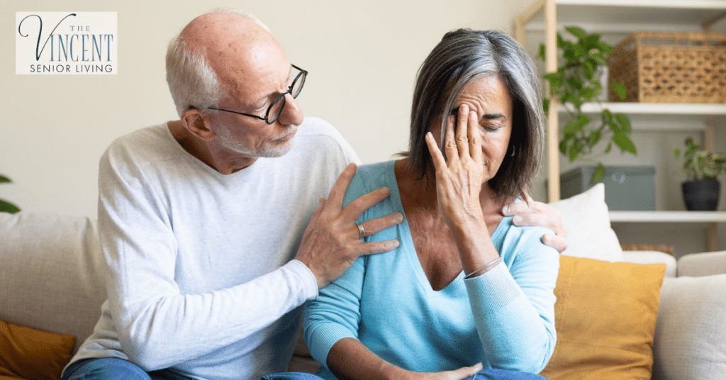 Senior man comforting an upset woman at home, illustrating supportive communication strategies for dementia.